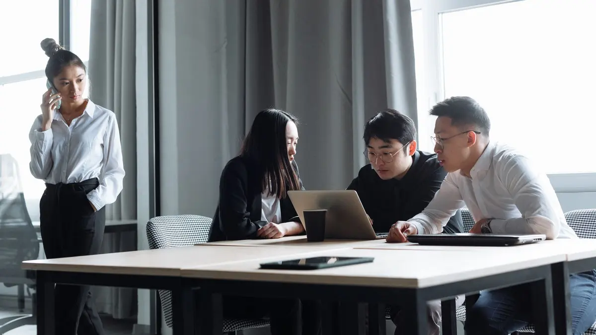 Young professionals working together on a laptop in a modern office, representing post-study work on the Australia 485 visa