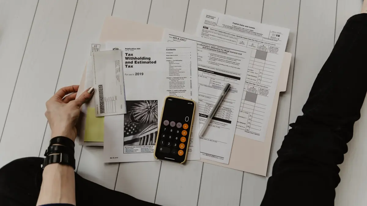 Calculator, bank statements, and a notebook for planning student visa funds