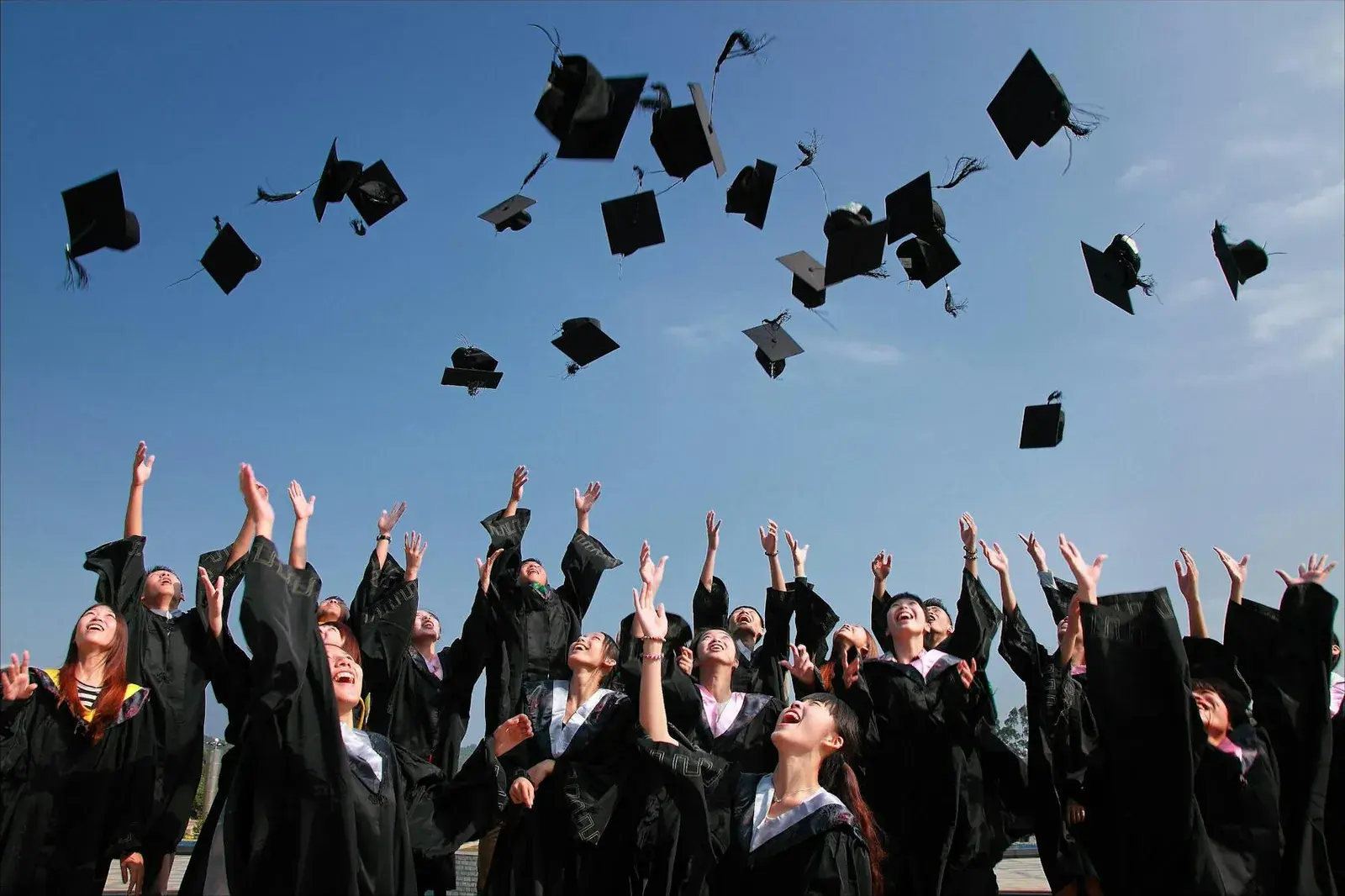 Graduates celebrating and throwing their caps into the sky